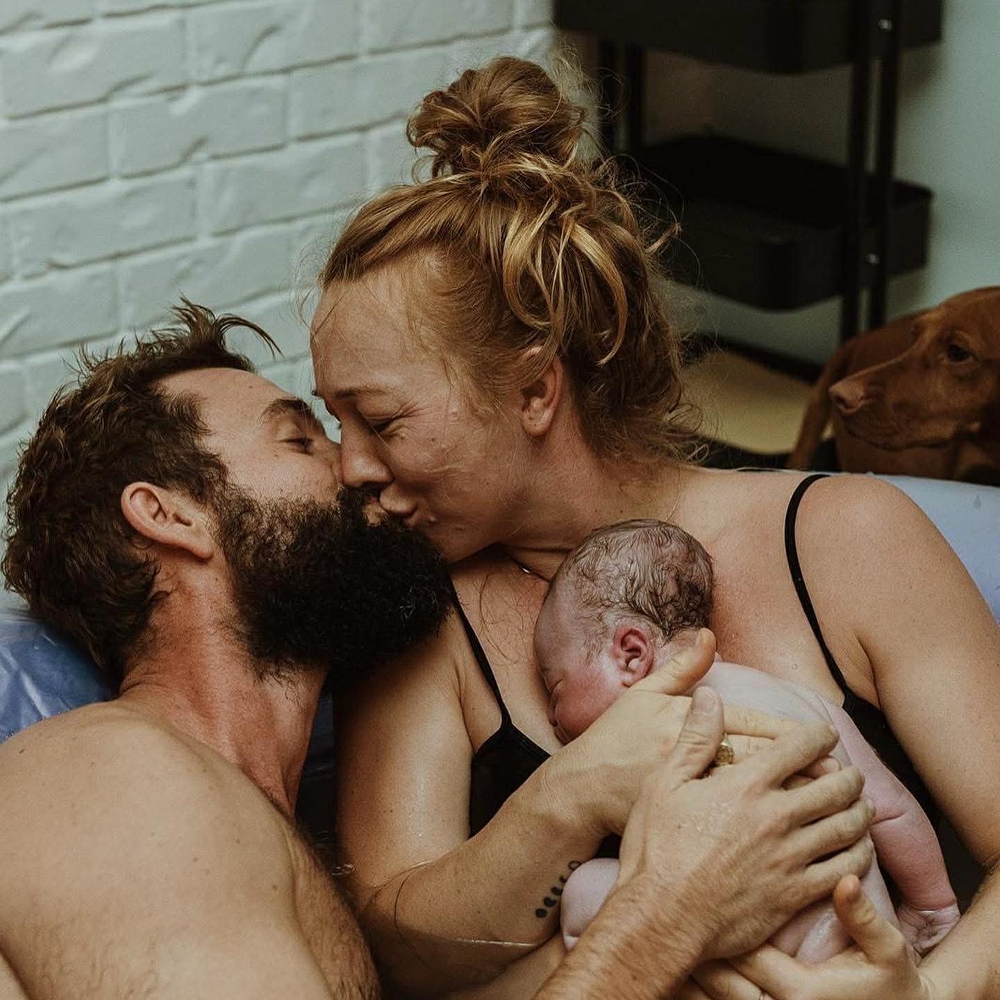 koppel met pasgeboren baby in bad